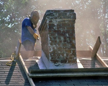 Man working on roof near chimney